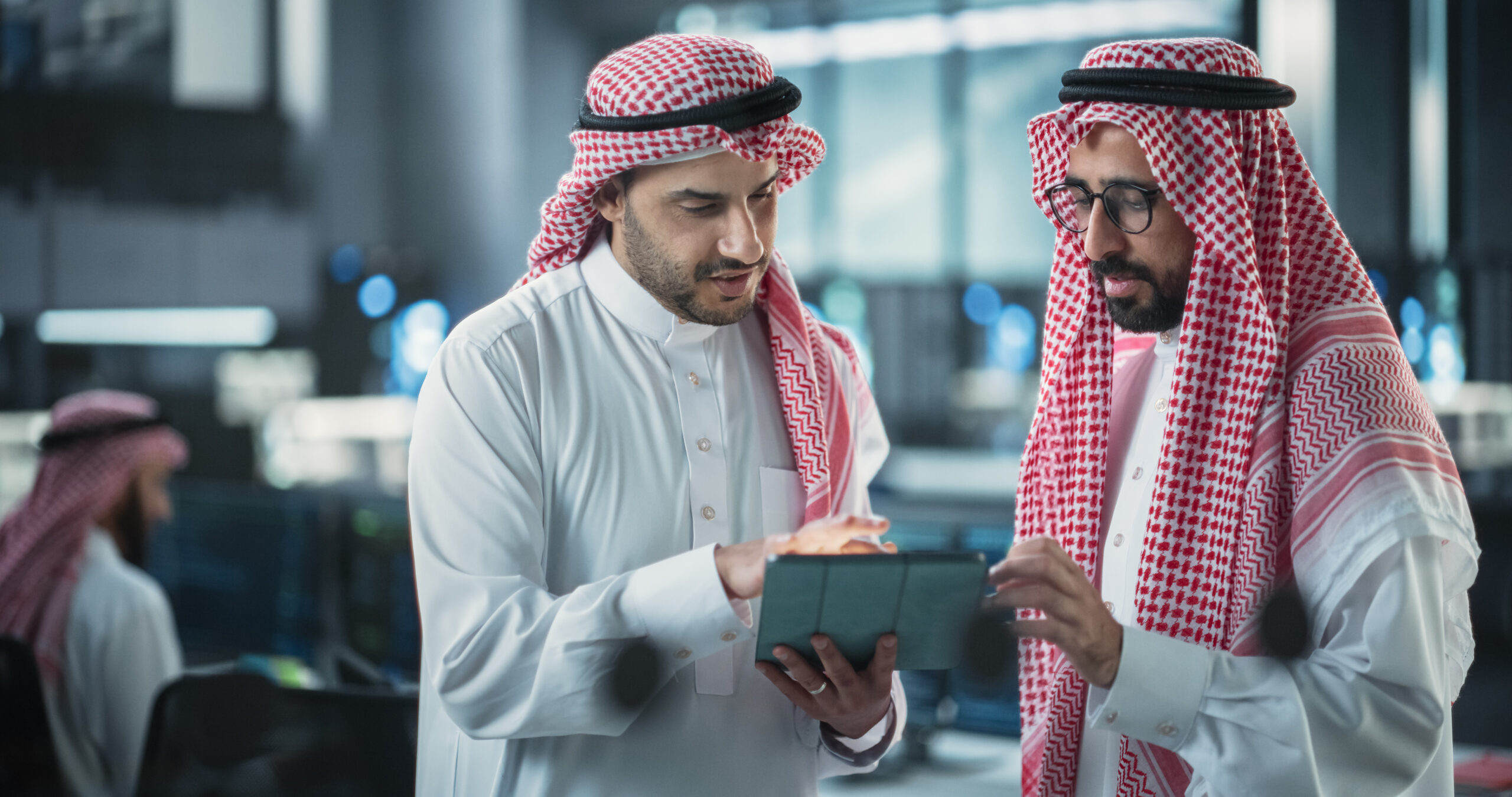 Two Young Muslim Software Engineers Use Tablet Computer to Discuss a Technological Project in a Modern Industrial Office. Arab Scientists Work in Research and Development Center